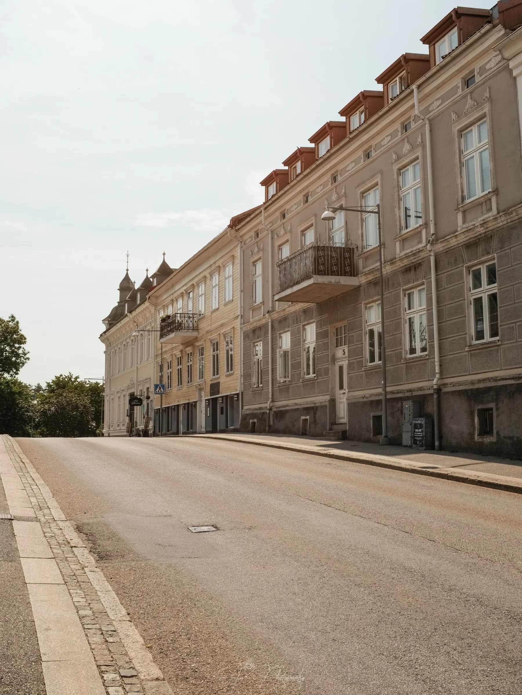 Lugn gata i Strömstads centrum, kantad av gamla trä- och putsfasader i eftermiddagsljus.